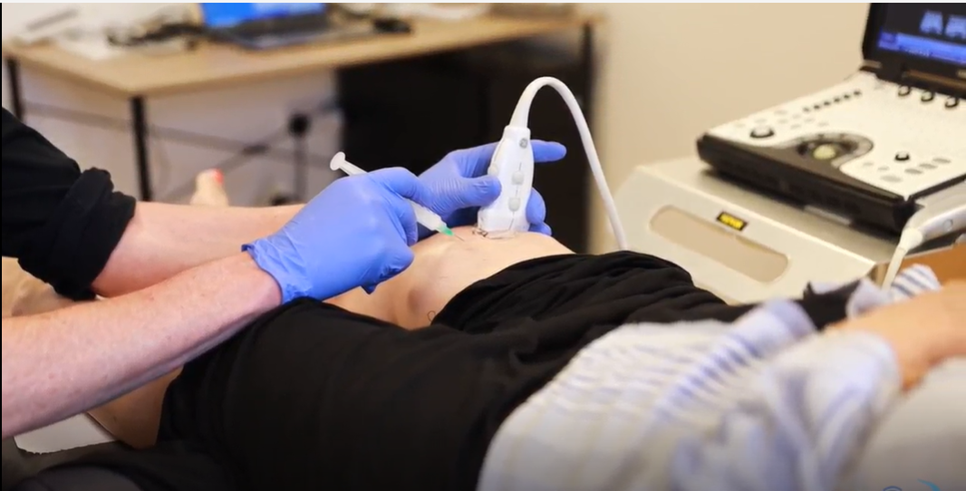 a person having ultrasound and knee injection in a clinic