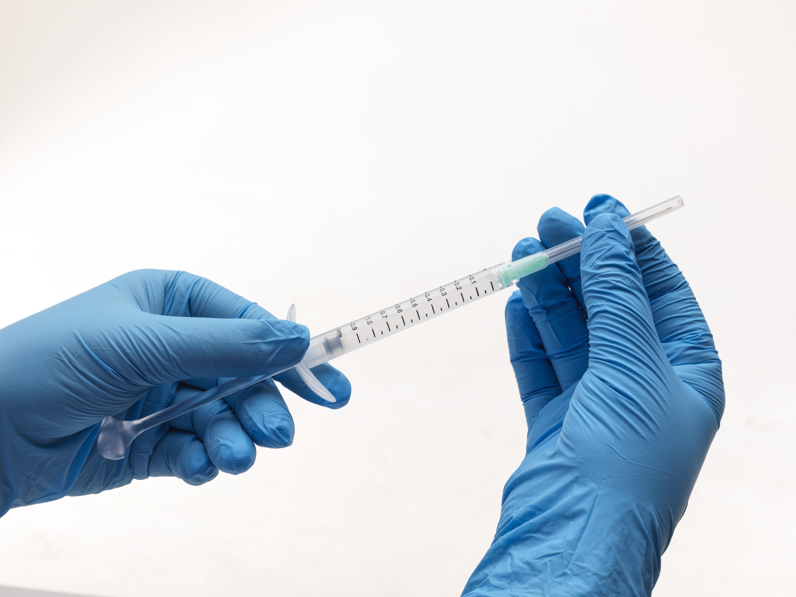 Arthrosamid 6 persons hands with gloves on holding a needle for arthrosamid injection